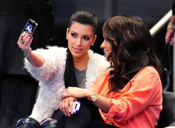 Kim Kardashian takes of picture at a New York Knicks game with her BlackBerry.