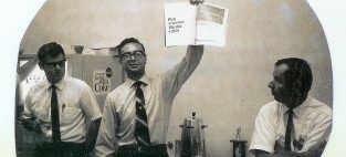 In 1969, Andy Grove, then COO, holds an advertisement for the Intel 3101, the world's first solid-state memory device and Intel's first product.